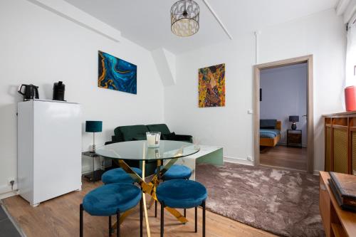 un salon avec une table et des chaises bleues dans l'établissement Two room apartment - centre historique, à Mulhouse
