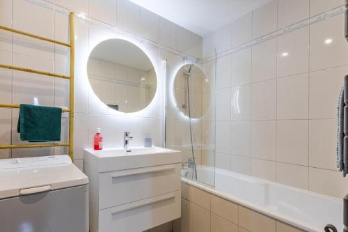 une salle de bain blanche avec un lavabo et un miroir dans l'établissement Quiet - Les Maraîchers - Terrace - Private garage, à Colmar