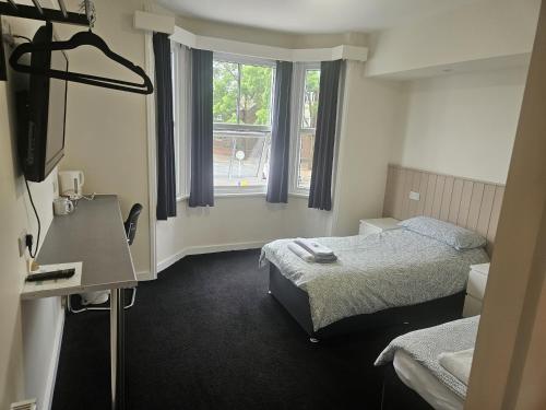 a hotel room with two beds and a window at The Swan Hotel in Milton Keynes