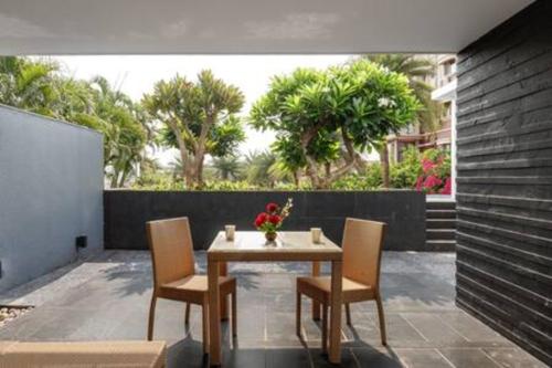 a table and chairs on a patio with trees at St Jacinto Island Villa10 2Pools Bay View in Dabolim