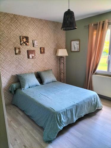 une chambre avec un lit bleu et une fenêtre dans l'établissement Maison circuit 24 heures du Mans, à Teloché