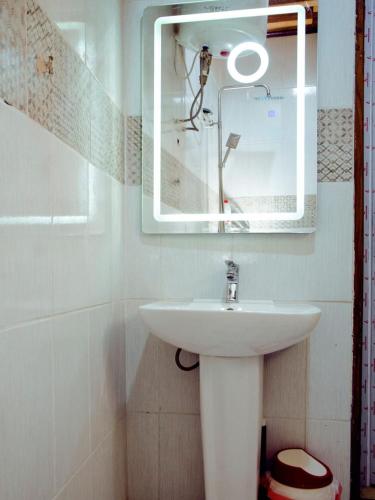 a bathroom with a sink and a mirror at Appartements Meublés Elégants et Spacieux à Tradex Ahala - Yaoundé in Yaoundé