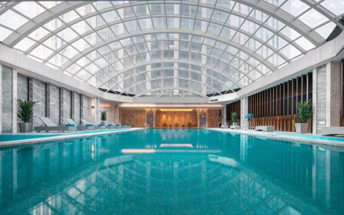 a large swimming pool with a glass ceiling at Kempinski Hotel Changsha in Changsha