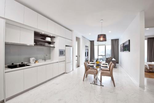 a kitchen and dining room with a table and chairs at THE FACE Suites in Kuala Lumpur