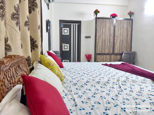 a bedroom with a bed with red pillows at Annamaiah Guest House & Homestay - Tirupati - Home Food Service in Tirupati