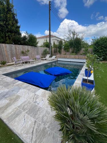 une piscine avec des tapis bleus dans une cour arrière dans l'établissement Appartement Balnéothérapie, à Cenon