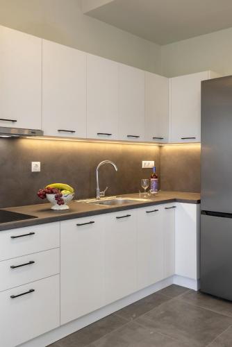 a kitchen with white cabinets and a sink at Elia Syros in Vari