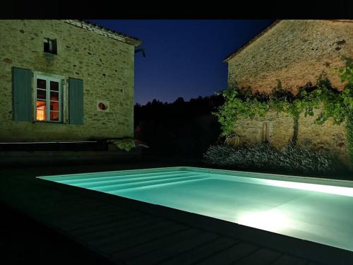 une piscine devant un immeuble la nuit dans l'établissement L' Ecurie, à Lavaur