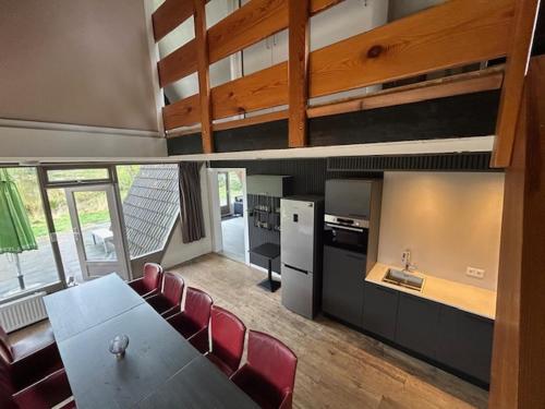 a dining room with a table and red chairs at Duo family bungalow Vosvilla Limburg in Stramproy