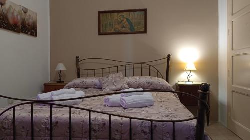 a bedroom with a bed with purple sheets and pillows at Casa Vacanze Nino Petrelli in Naso