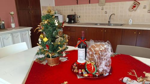 a kitchen table with a bottle of wine and a christmas tree at Casa Vacanze Nino Petrelli in Naso