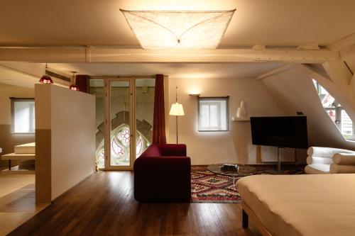 a bedroom with a bed and a living room at Kruisherenhotel Maastricht - Oostwegel Collection, member of Design Hotels in Maastricht