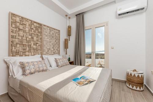 a bedroom with a large bed with two books on it at Ruby of Naxos Residences in Kastraki