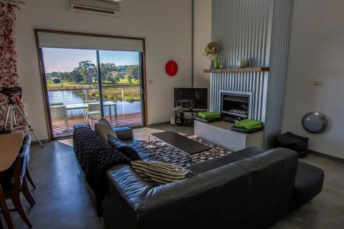 sala de estar con sofá de cuero y chimenea en Tonic Hotel, en Lovedale