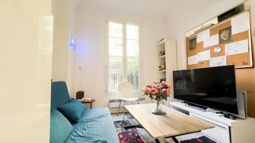 un salon avec un canapé bleu et une télévision dans l'établissement studio nice liberation, à Nice