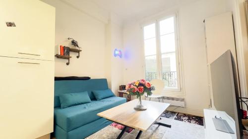 un salon avec un canapé bleu et une table dans l'établissement studio nice liberation, à Nice