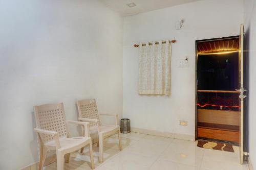 Habitación con 2 sillas y chimenea en Vallyview's Residency, en Panchgani
