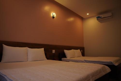 two beds in a hotel room with at KHÁCH SẠN ĐẾ VƯƠNG in Cao Lãnh