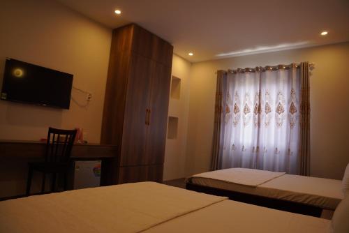 a hotel room with two beds and a television at KHÁCH SẠN ĐẾ VƯƠNG in Cao Lãnh