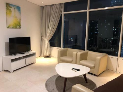 a living room with a couch and a tv and a table at VORTEX SUITES KLCC By ASTRA in Kuala Lumpur