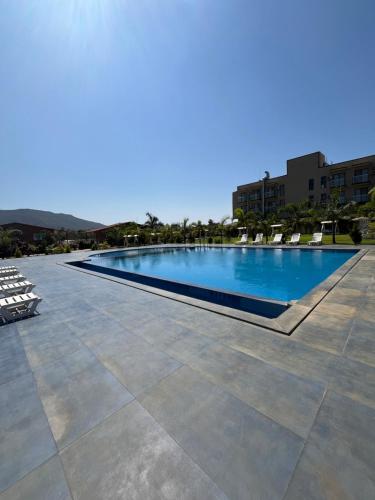 a large swimming pool with chairs on a patio at Daksh The Valley Resort - Saputara in Saputara