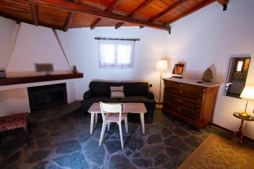 a living room with a couch and a table at Fteri Stone House in Platanos, Akrata in Plátanos