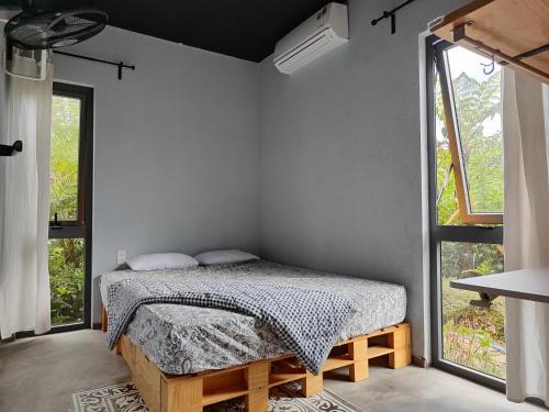 a bedroom with a bed and a window at MAI HOTAY Lakeside Highland Retreat Homestay in Ðức Lập