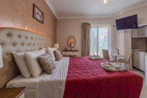 a bedroom with a large bed with a red blanket at Knights' Castle Studios in Archangelos
