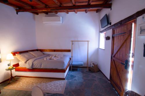 a bedroom with a bed and a sliding glass door at Fteri Stone House in Platanos, Akrata in Plátanos