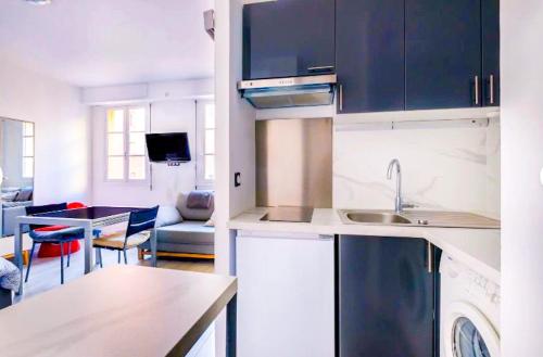 une cuisine avec des armoires bleues et un salon dans l'établissement beautiful apartment port de nice, à Nice