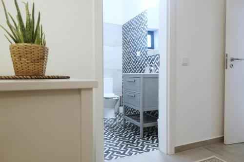 a bathroom with a sink and a desk with a potted plant at Endless Ocean - Praia da Luz in Luz