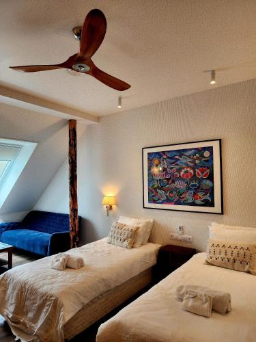 a bedroom with two beds and a ceiling fan at Mia Hotel in Orissaare