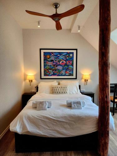 a bedroom with a large bed with a ceiling fan at Mia Hotel in Orissaare
