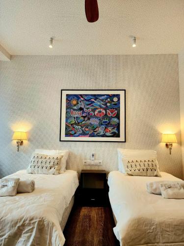 two beds in a room with a painting on the wall at Mia Hotel in Orissaare