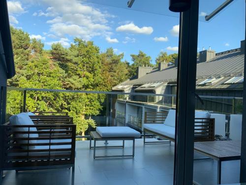 a balcony with chairs and tables on a building at Apartament Dwie Sosny Patrycja in Ustronie Morskie