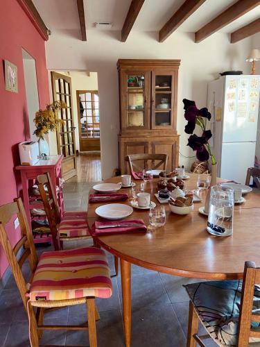 een houten tafel in een keuken met een tafel en stoelen bij La Colline aux Licornes in Montbron