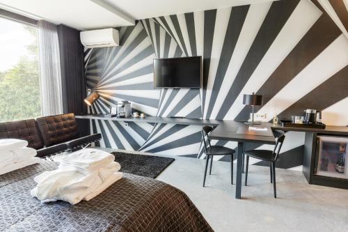 a hotel room with a bed and a desk at La Marquise luxe vakantiehuis in Budel