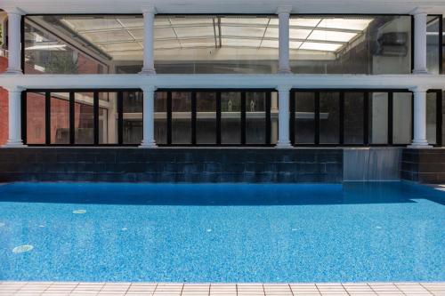 a building with a blue pool in front of it at RVHotels Broquetas Spa Termal in Caldes de Montbui