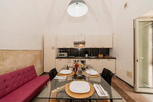 a living room with a table and a red couch at CASA PAPADIA in Uggiano la Chiesa