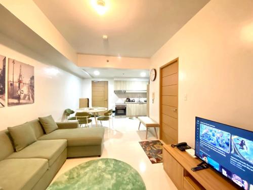 a living room with a couch and a flat screen tv at Premium East Gate 1BR unit in Cebu City