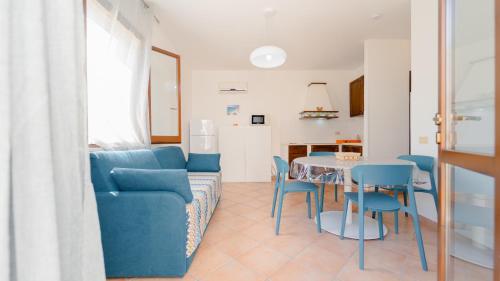 a living room with a blue couch and a table and chairs at Residence Favonio in Favignana