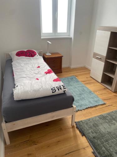 a bedroom with a bed with white sheets and red roses at AVIZJA Living in Korneuburg