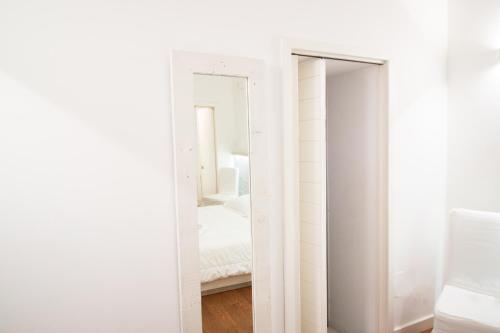 a white closet with a mirror and a bed at Sui Tetti Luxury Rooms in Lecce