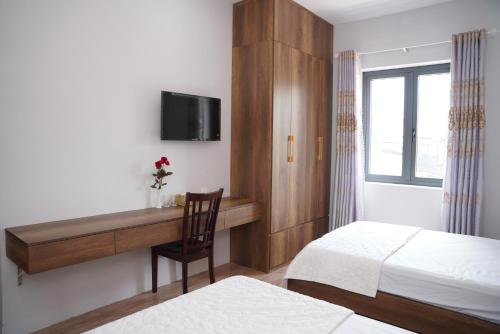 a bedroom with a bed and a desk with a tv at KHÁCH SẠN ĐẾ VƯƠNG in Cao Lãnh