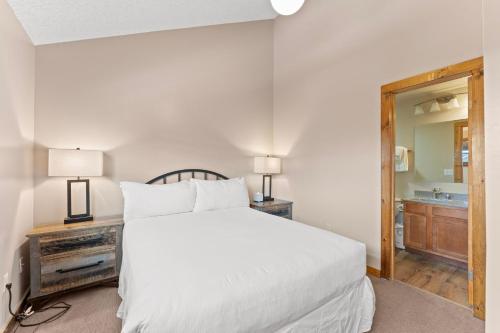a bedroom with a white bed and a bathroom at Rockridge 51 by Summit County Mountain Retreats in Breckenridge