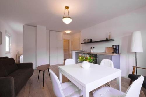 a living room with a white table and white chairs at Charmante Ferienwohnung 2 im Schmöllerhäuschen in Stadt Wehlen