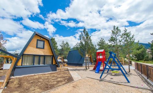 a playground with a house and a slide at Natural Dream Blidinje in Rudo Polje