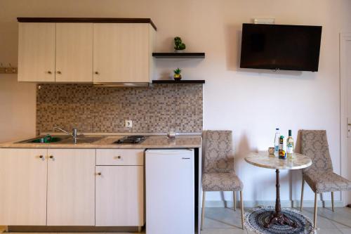 a kitchen with a sink and a table with chairs at Knights' Castle Studios in Archangelos