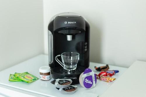 une cafetière noire assise sur un comptoir avec des bonbons dans l'établissement Versailles chic et cosy, à Versailles