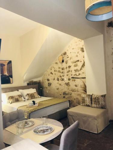 a hotel room with two beds and two tables at Gaia Luxury Rooms Rethymno in Rethymno Town